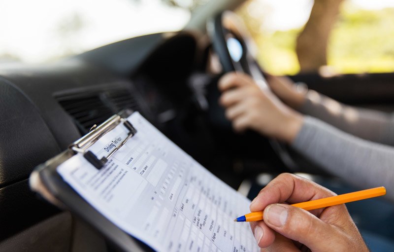 בוחן נהיגה במהלך הבחינה בנסיעה ברכב רושם הערות בטופס